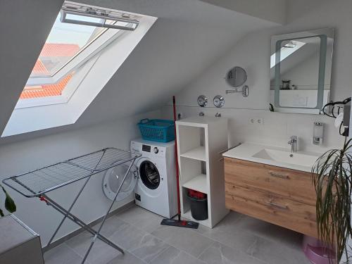 a bathroom with a washing machine and a sink at Ferienwohnung-Vetter in Bodelshausen