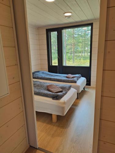 two beds in a small room with a window at Minikoti in Oulu