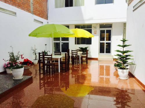 een patio met tafels en stoelen met parasols bij HOTEL CASTILLO MAGICO (EX CHAVIN SEÑORIAL? in Barranca