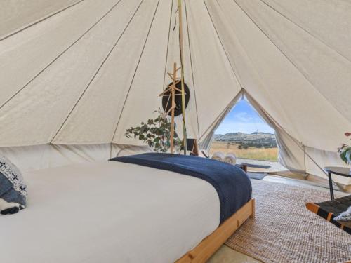 a bedroom with a bed in a tent at Glenayr Farm in Windeyer