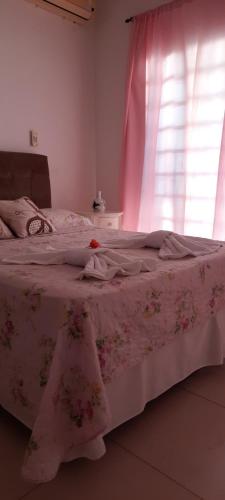 a bedroom with a bed with a pink blanket and a window at A KAsinha do Murubira in Mosqueiro
