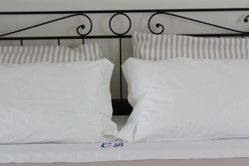 1 cama con almohadas blancas y cabecero negro en B&B Casa Benvenuto, en Diamante