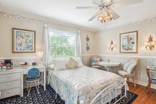 a bedroom with a bed and a table and a window at Banyan House Vacation Rentals in Venice