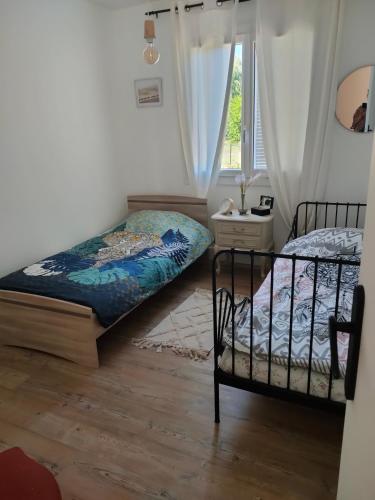 une chambre avec deux lits et une fenêtre dans l'établissement Maison avec jardin Auxerre, à Saint-Georges-sur-Baulche