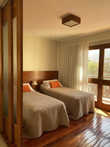 a bedroom with two beds and a window at Santa Fe Suites Apart in Salta