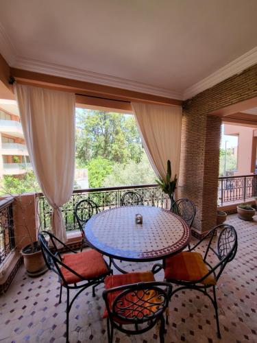 a patio with a table and chairs on a balcony at Résidence Prestige in Marrakesh