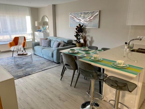 cocina y sala de estar con mesa y sofá en El piso de Nore, en Vigo