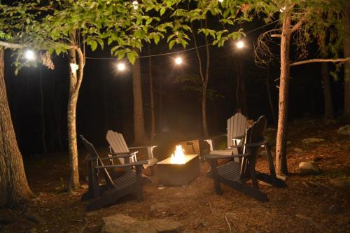 two chairs and a fire pit at night at In The Woods - 5 BR Chalet with Game Room, Fire Table and Hot Tub in McGaheysville