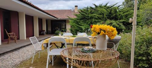 a table with chairs and a vase with flowers on it at Casa de Levandeiras in Barcelos