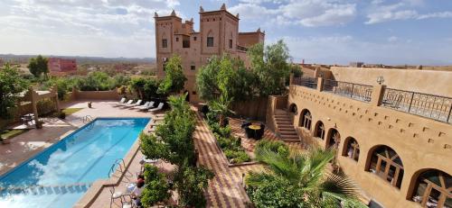 an apartment with a swimming pool and a building at Kasbah Ait BenHadda in Skoura