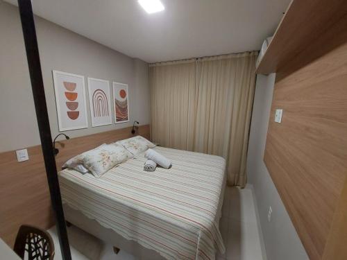 a small bedroom with a bed with striped sheets at Flat Buenos Ayres Cabo Branco in João Pessoa