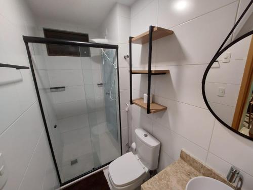 a bathroom with a toilet and a glass shower at Flat Buenos Ayres Cabo Branco in João Pessoa