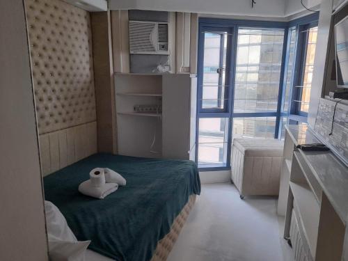 een kleine kamer met een bed met een knuffeldier erop bij Grand Riviera Suits in Manilla