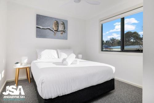 a white bedroom with a bed and a window at Berridale Bliss in Berridale