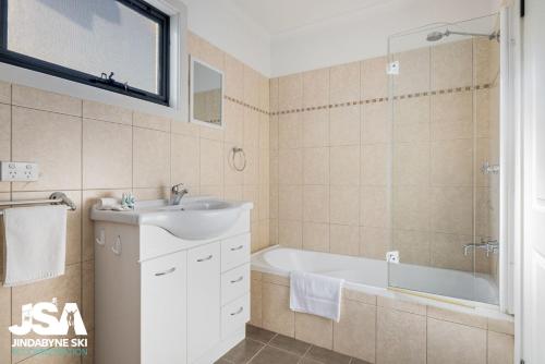 ein Badezimmer mit einem Waschbecken und einer Badewanne in der Unterkunft Berridale Bliss in Berridale