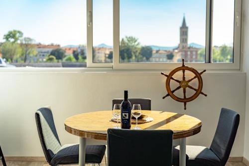 tavolo da pranzo con una bottiglia di vino e sedie di Captain’s Apartment a Zara (Zadar)