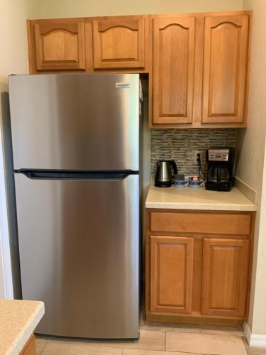 a stainless steel refrigerator in a kitchen with wooden cabinets at Venetian Vacation in Venice