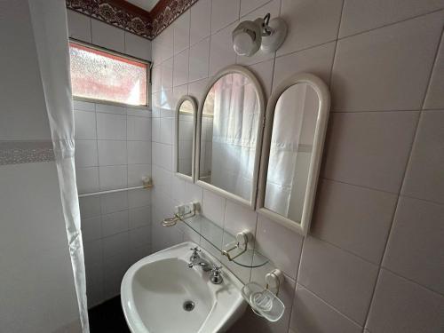 a white bathroom with a sink and a mirror at Casa en SAN LUIS in San Luis