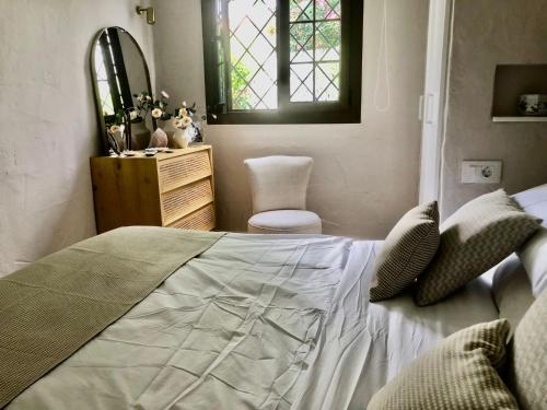 ein Schlafzimmer mit einem Bett, einem Stuhl und einem Fenster in der Unterkunft Santa Clara Bungalows in Maspalomas
