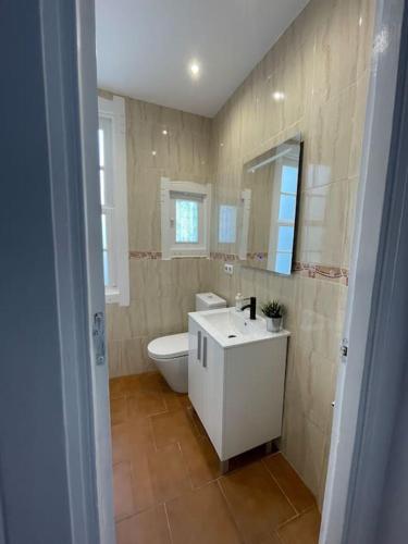 ein Badezimmer mit einem WC, einem Waschbecken und einem Spiegel in der Unterkunft Atico Vintage con Terraza in Vigo