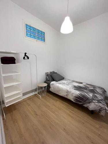 1 dormitorio blanco con 1 cama y suelo de madera en Atico Vintage con Terraza en Vigo