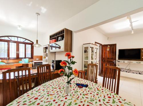 comedor y cocina con mesa y sillas en Casa vista para montanha Pet Friendly en Caraguatatuba