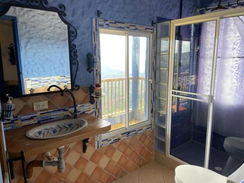 a bathroom with a sink and a mirror and a balcony at Hacienda Palomas en Concordia - Finca Cafetera in Salgar