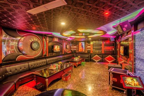 a room with a bar with a couch and tables at Muong Thanh Luxury Can Tho Hotel in Can Tho
