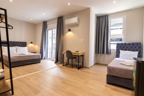 a hotel room with two beds and a desk at New Amaryllis Hotel in Athens