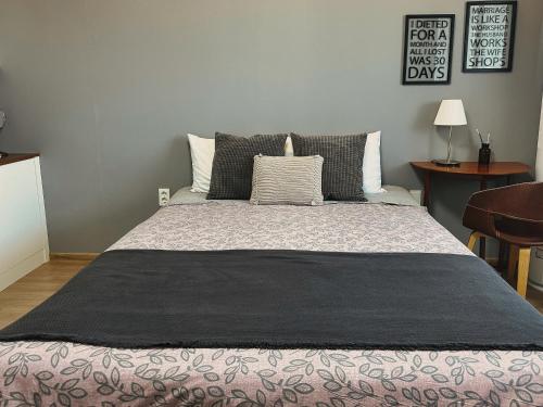 a bedroom with a large bed with a black blanket at Aewol Bada Poomeun Property in Jeju