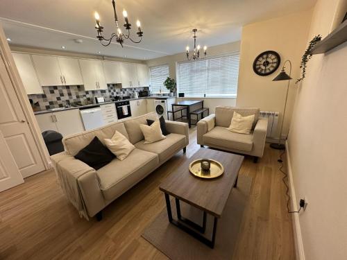 een woonkamer met een bank en een tafel bij Charming 2-Bed Apartment in Danbury essex in Chelmsford