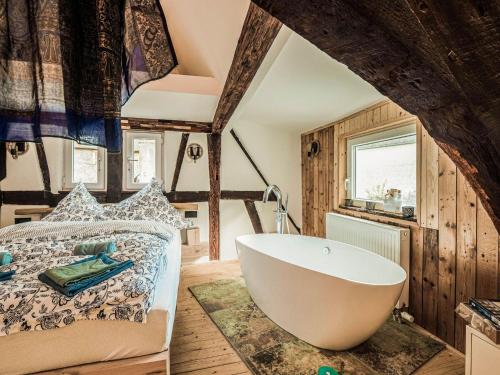 a bathroom with a bath tub next to a bed at Cosy holiday home in Sankt Goarshausen with barbecue in Sankt Goarshausen