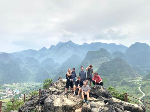 a group of people sitting on top of a mountain at Ha Giang Loop Rabbit Hostel & Tours in Ha Giang