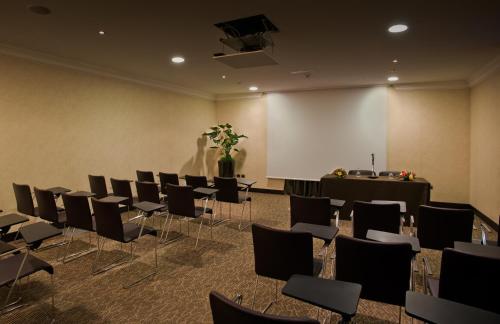 a conference room with chairs and a white screen at Hotel Regina Margherita in Cagliari