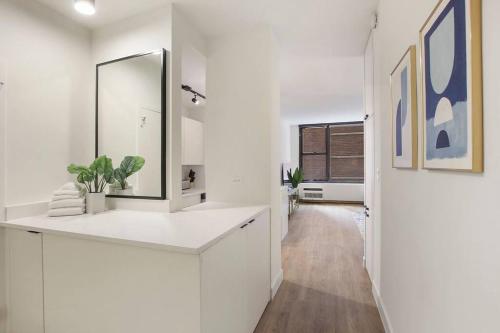 a white bathroom with a sink and a mirror at Simple and Cozy Studio Apartment- Chestnut 04D in Chicago