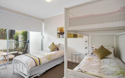a bedroom with two bunk beds and a balcony at No 7 Summer Salts in Hayborough
