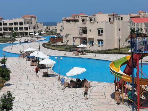 een zwembad met een glijbaan en een waterpark bij Pharma beach resort قريه الصيادلة - Chalet - zero ten six four one seven six five zero nine in Balṭîm