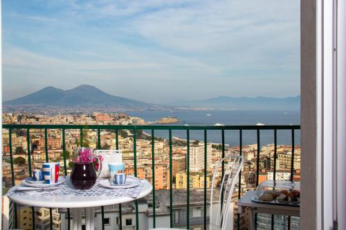 a balcony with a table with a view of a city at Nido Dei Gabbiani in Naples