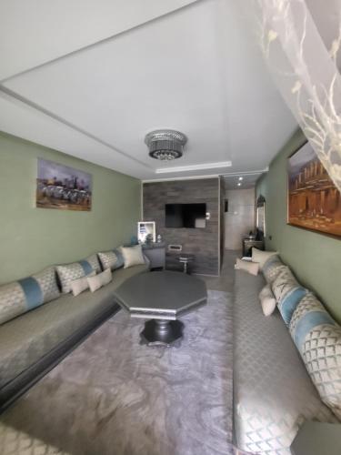 ein Wohnzimmer mit einem Sofa und einem Tisch in der Unterkunft Appartement de luxe sur agadir bay in Agadir
