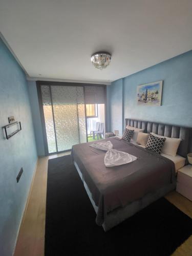 um quarto com uma cama grande e uma janela grande em Appartement de luxe sur agadir bay em Agadir