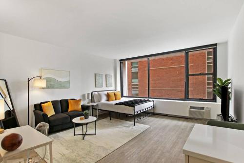 a living room with a couch and a window at Serene & Completely Furnished Studio Apartment- Chestnut 14F in Chicago