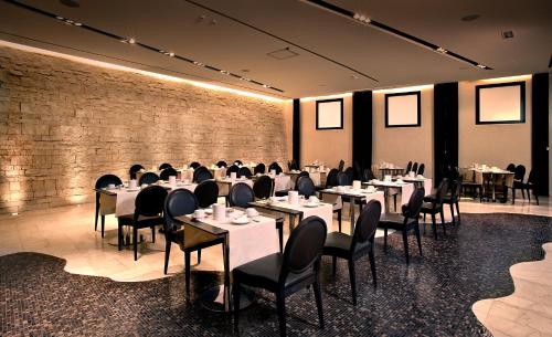 a dining room with tables and chairs and a brick wall at Hotel Regina Margherita in Cagliari