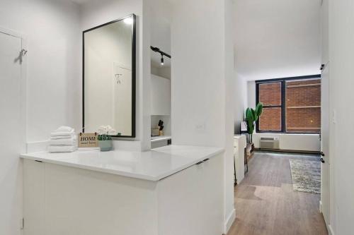 uma casa de banho branca com um lavatório e um espelho em Inviting & Fully Furnished Studio Apartment - Chestnut 02D em Chicago