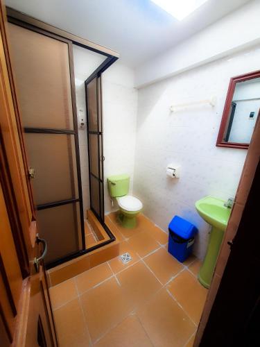 La salle de bains est pourvue de toilettes vertes et d'un lavabo. dans l'établissement Cabañas Utama, à Copacabana