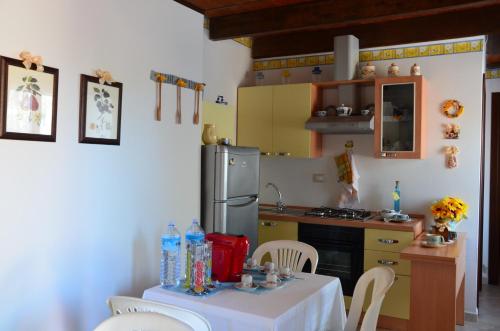 een keuken met een tafel en een koelkast bij La Vecchia Montagna B&B in Nebida