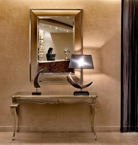 a dressing table with a lamp and a mirror at Hotel Regina Margherita in Cagliari