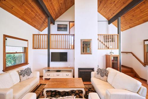 a living room with a couch and a table at Wandin Valley Estate in Lovedale