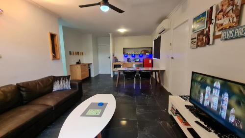 een woonkamer met een bank en een flatscreen-tv bij The Good Life in Port Pirie