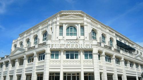 um edifício branco com uma placa na frente dele em The George Penang by The Crest Collection em George Town