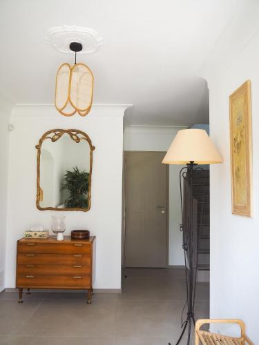 a room with a mirror and a dresser and a lamp at Mas Grenadine, magnifique villa du Piémont Cévenol in Sauve